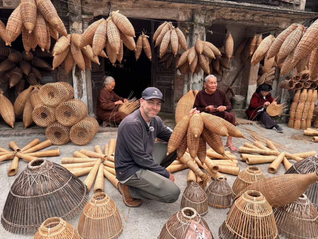 Hundreds of handwoven bamboo fish-trap baskets drying outside a workshop in a traditional Vietnamese craft village